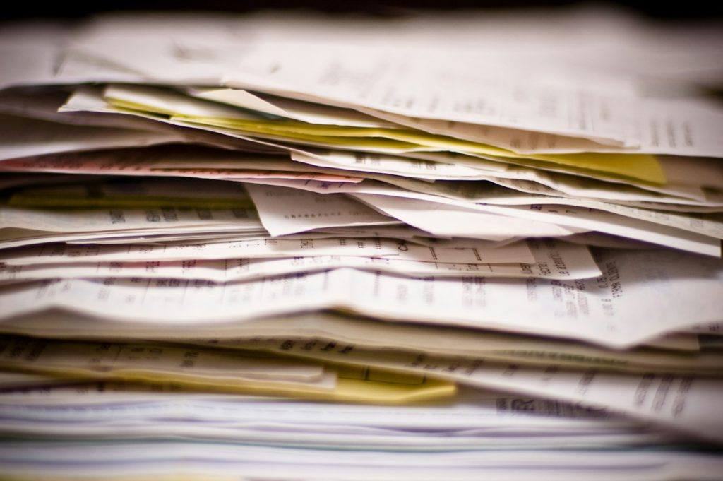 Thick stack of invoices and financial paperwork piled up