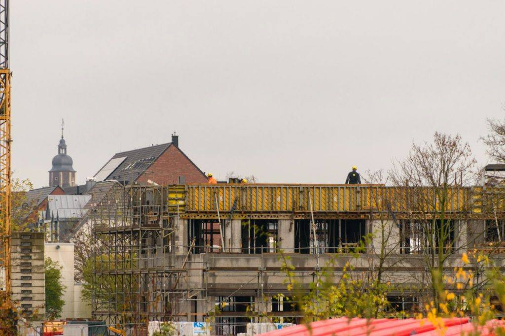 Construction workers on a building site with a tower crane overhead