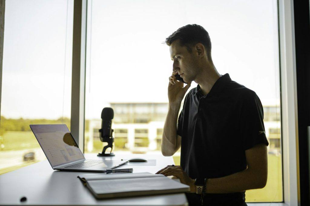 Salesperson on a phone call while working at his office desk