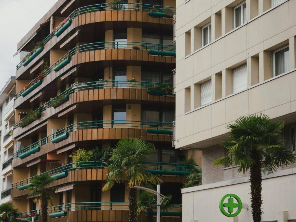 Modern apartment buildings with rows of balconies and palm trees