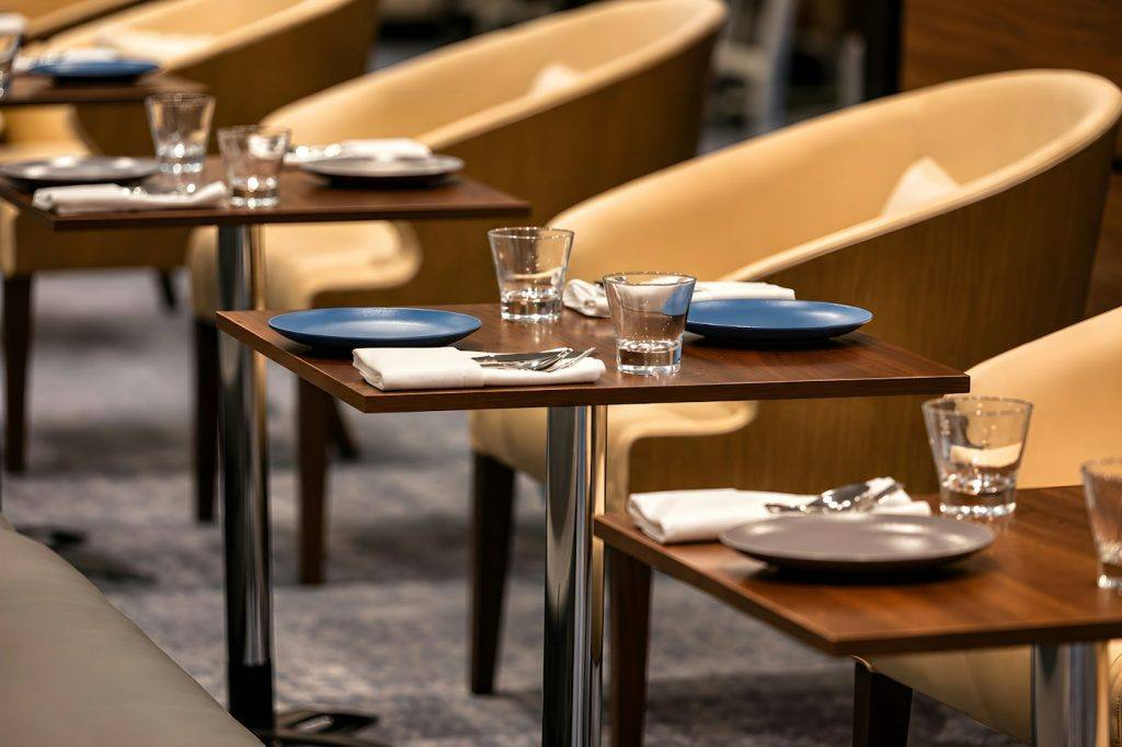 Restaurant dining room with set tables and yellow chairs