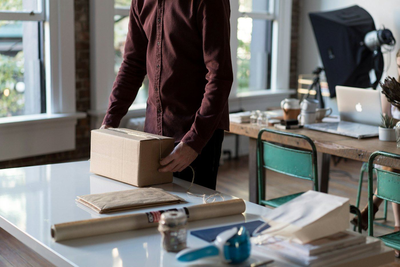 Store owner packing an online order into a shipping box